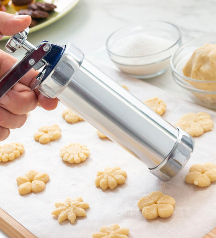 InnovaGoods 2-in-1 cookie press and decorating gun for baking, with metal parts and colorful handles for easy use in the kitchen.
