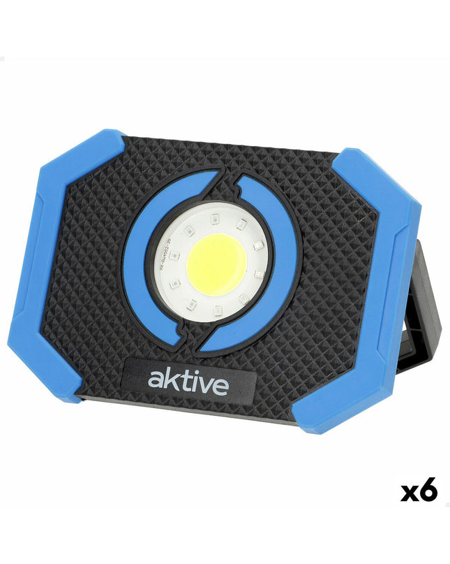 Set of six Aktive LED spotlight outdoor garden decor lights illuminating a garden area at night.